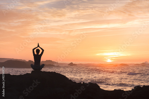 Woman fighting stress by practicing yoga near the sea