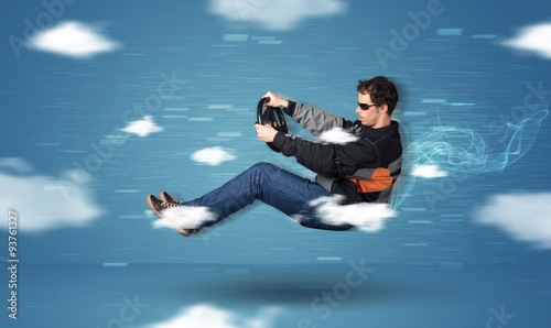Funny racedriver young man driving between clouds concept © ra2 studio