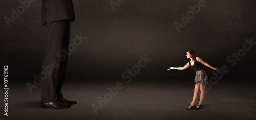 Huge man with small businesswoman standing at front concept