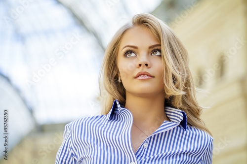 Portrait of a beautiful blonde in a blue striped shirt
