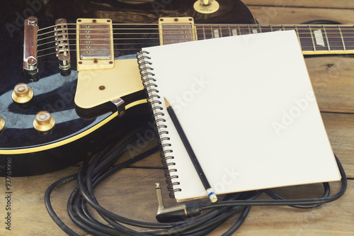 electricguitar with notepad on wood table