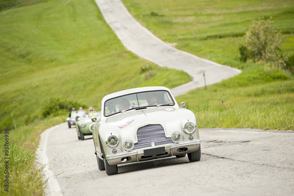 Auto classica che percorre una strada piena di tornanti Auto classica che percorre una strada piena di tornanti
