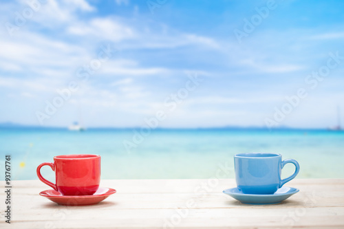 Two cups of coffee on table with sea