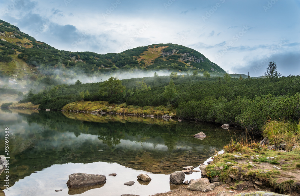 birth of a cloud over lake in mountains birth of a cloud over lake in mountains
