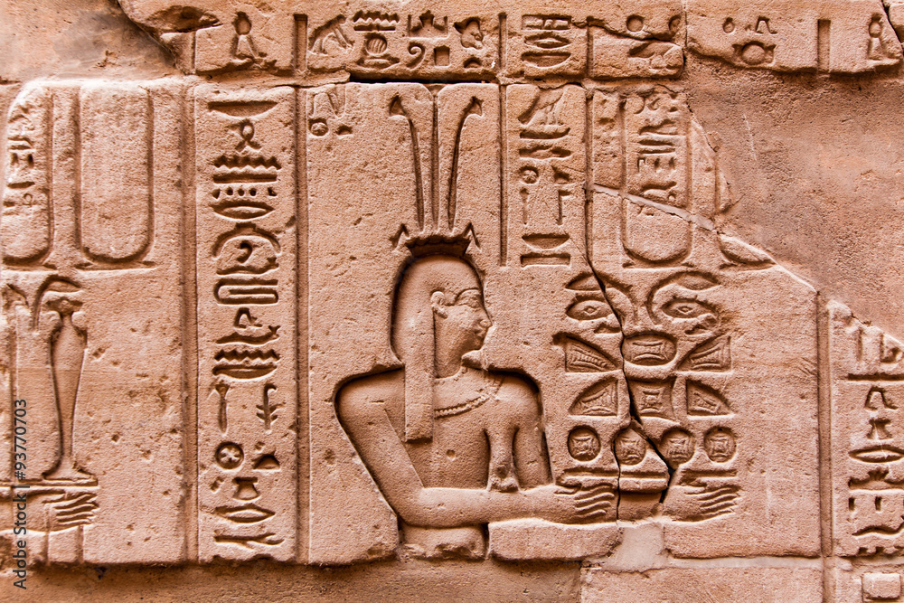 Egyptian hieroglyphics on the stone wall. Ancient stone carved E Egyptian hieroglyphics on the stone wall. Ancient stone carved E