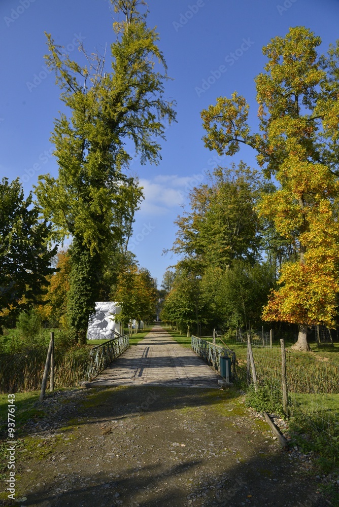 Vers le pont en bois sous la nature automnale au parc du château de Seneffe en Hainaut Vers le pont en bois sous la nature automnale au parc du château de Seneffe en Hainaut