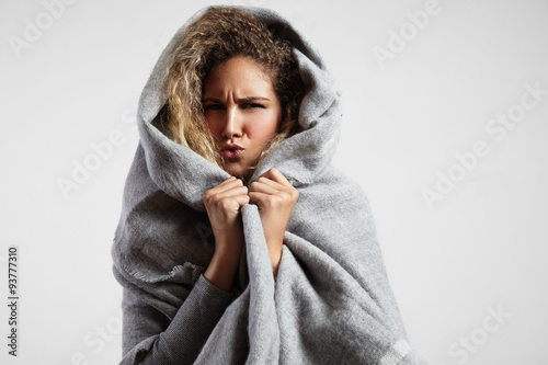 woman feeling freeze and wrap up in a blanket