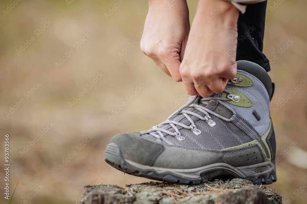 woman on a hiking trail ties the shoelace on her walking shoe, woman on a hiking trail ties the shoelace on her walking shoe,