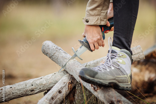 woman cutting a wood with a hand electric saw