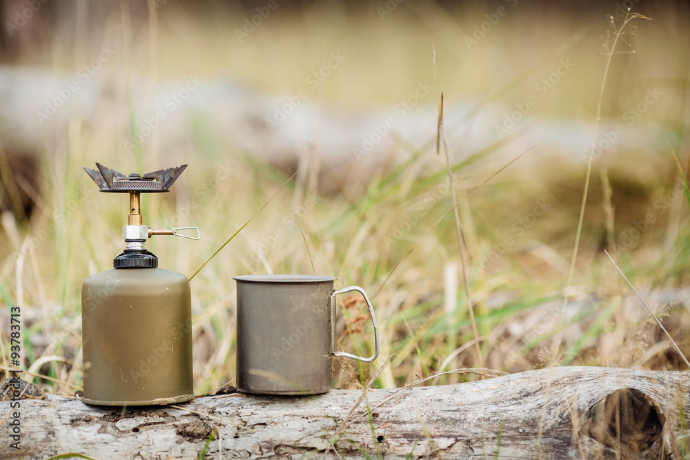 gas stove with titanium mug on the forest background