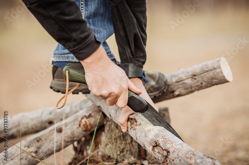 yang Man cutting a wood with a hand saw