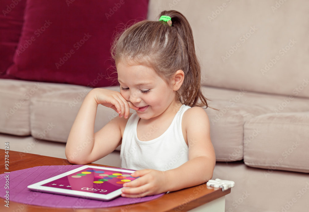 cute little girl playing with tablet computer at home cute little girl playing with tablet computer at home