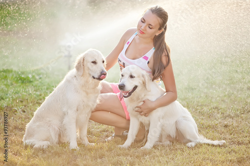 Beautiful woman with two labradors in a forest