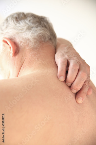 Senior tries to scratch his bare back 