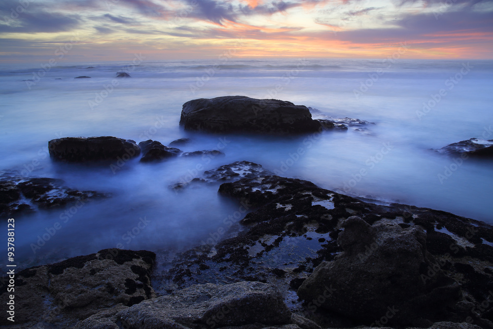 Twilight / A seascape at twilight, rocks washed by the sea under a sunset afterglow