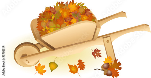 Wooden wheel barrow full with autumn leaves
