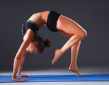 Young woman doing yoga exercise on mat