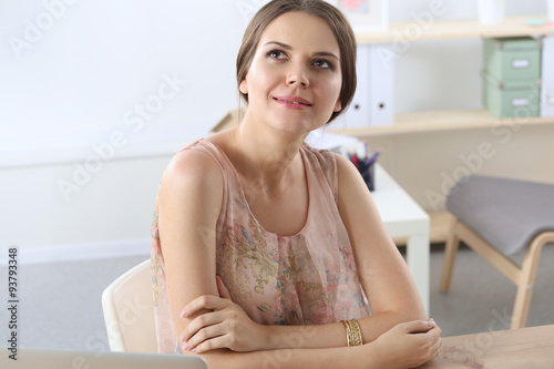Attractive businesswoman sitting  on desk in the office © lenets_tan