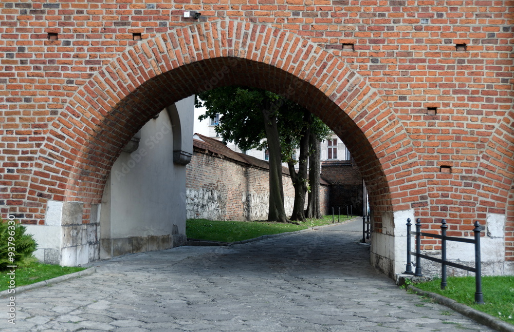 Cobblestone alley under the arch behind Corpus Christi Basilica