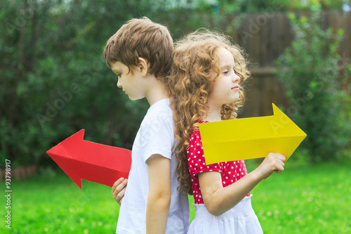 Tablou pe pânză Children holding color arrow pointing right and left, in summer