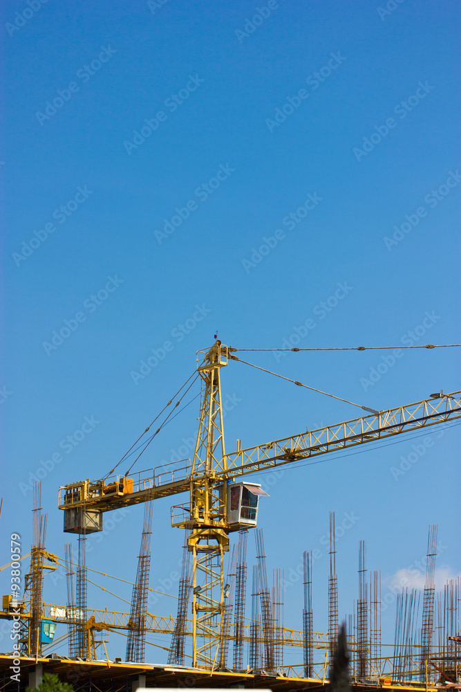 Construction site with crane isolated on blue sky.