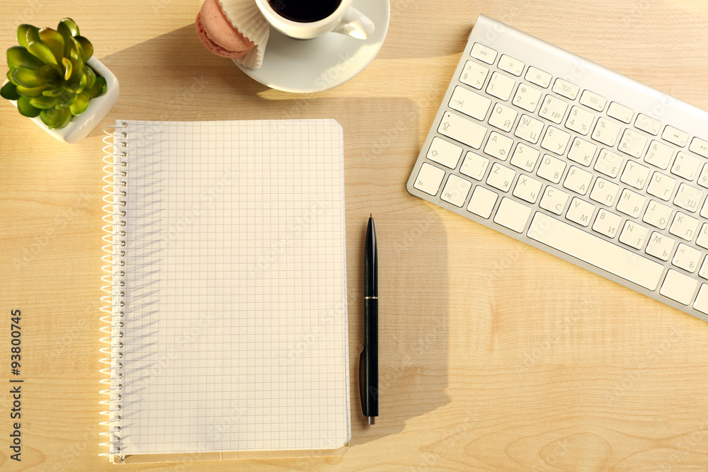 White keyboard and notebook on the desk White keyboard and notebook on the desk