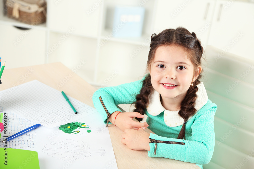 Cute little girl doing her homework, close-up, on home interior background Cute little girl doing her homework, close-up, on home interior background