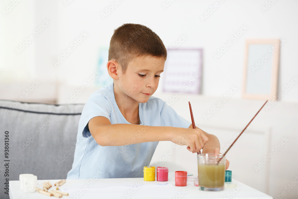 Cute little boy painting picture on home interior background Cute little boy painting picture on home interior background