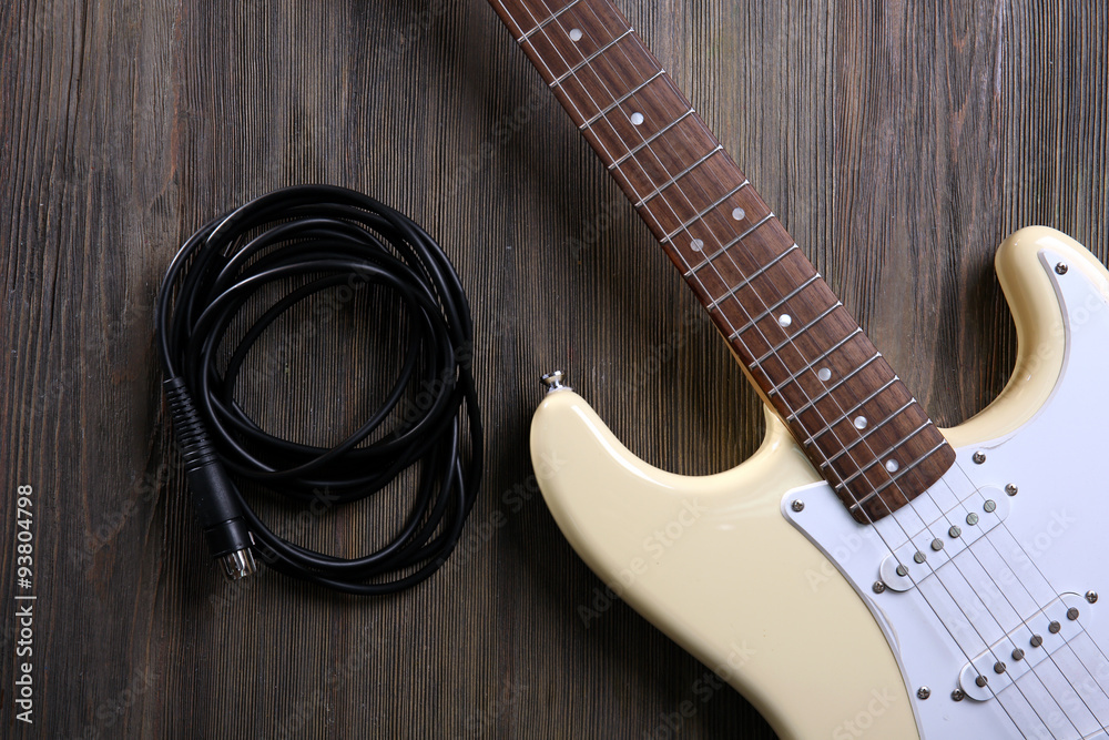 Fototapeta premium Guitar with cord on wooden background