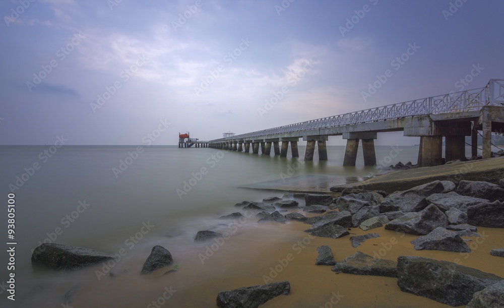 Fototapeta premium A sandy beach beside a services jetty in long exposure