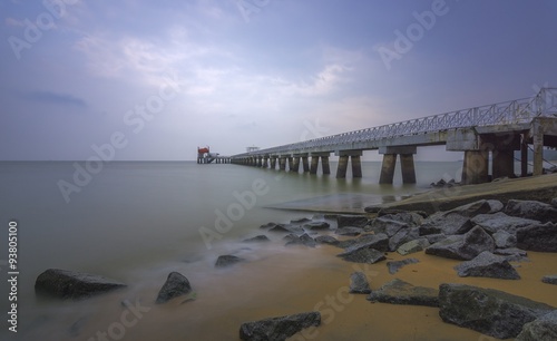 A sandy beach beside a services jetty in long exposure