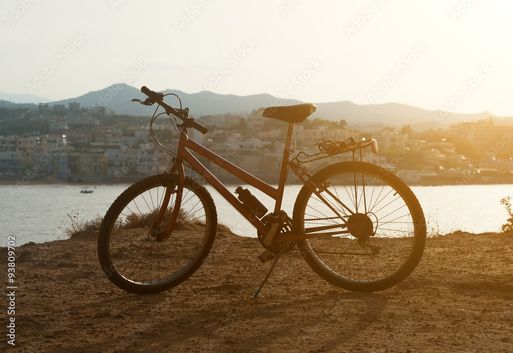 Fototapeta premium Red bicycle on the hill at sunset.