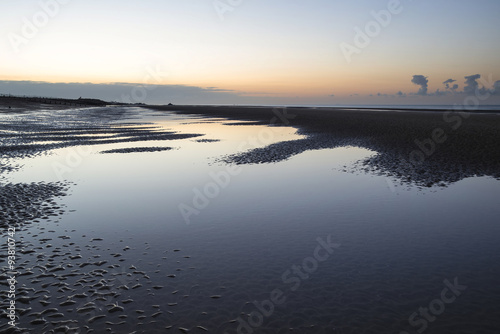 Beautiful tranquil sunrise over low tide beach