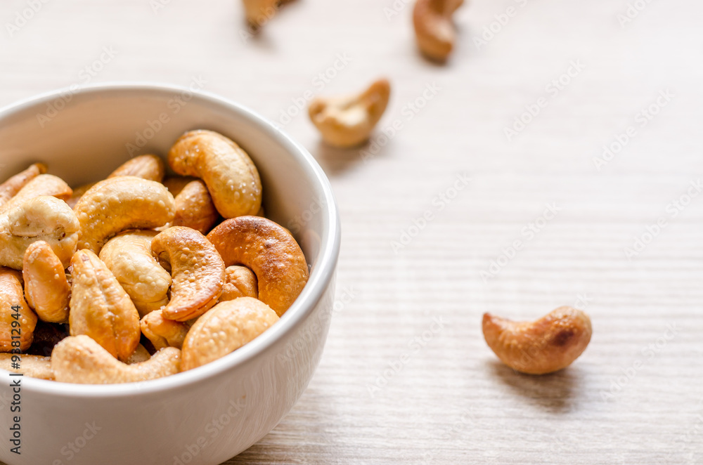 Fototapeta premium Close up cashew nuts on wooden background