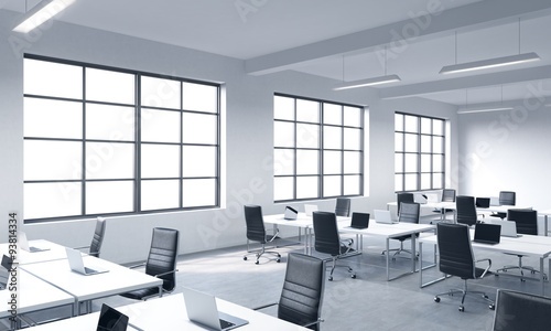 Corporate workplaces equipped by modern laptops in a modern panoramic office with white windows. Black leather chairs and white tables. 3D rendering.