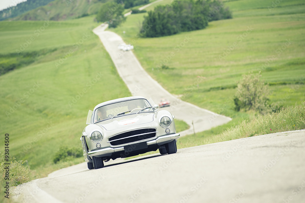 Auto classica su strada collinare Auto classica su strada collinare
