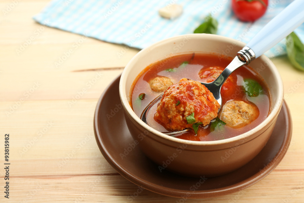Tomato soup with meat balls on wooden spoon on wooden background Tomato soup with meat balls on wooden spoon on wooden background