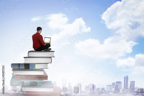 Business person working with laptop on  the top of books