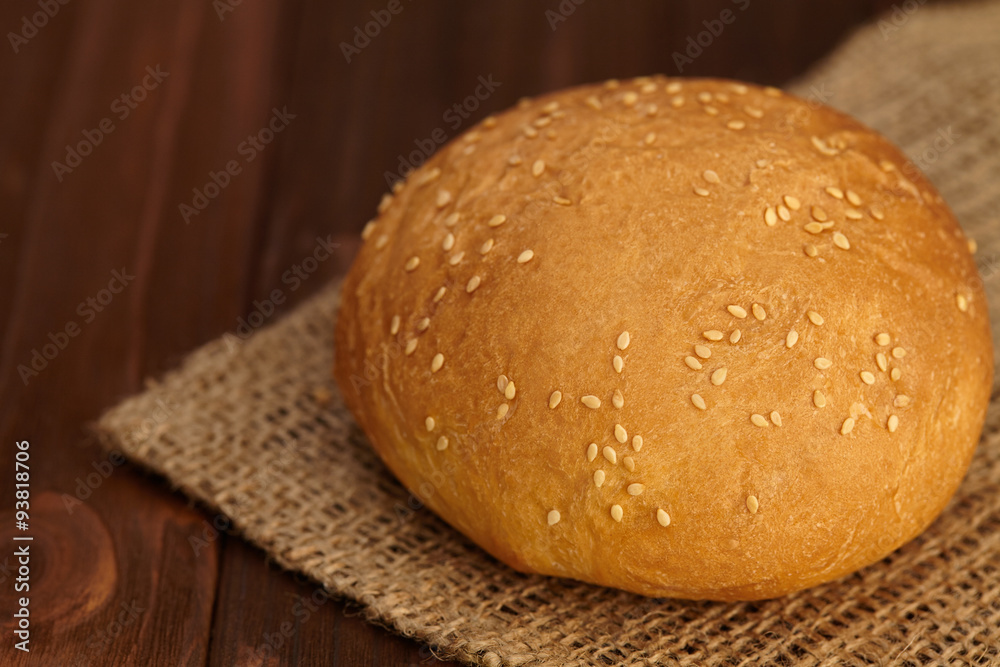 Fresh crispy bun on a wooden background