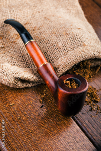 Smoking pipe and tobacco on brawn  wooden table.