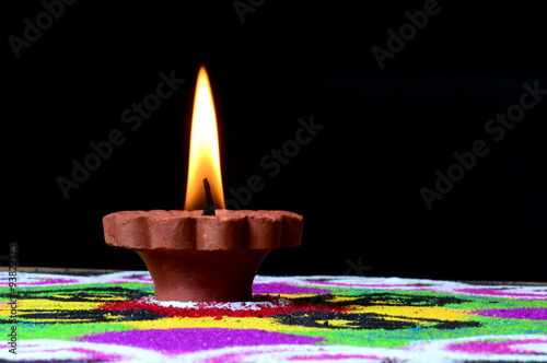 Clay diya lamps lit during diwali celebration. Greetings Card Design Indian Hindu Light Festival called Diwali. Rangoli in background
