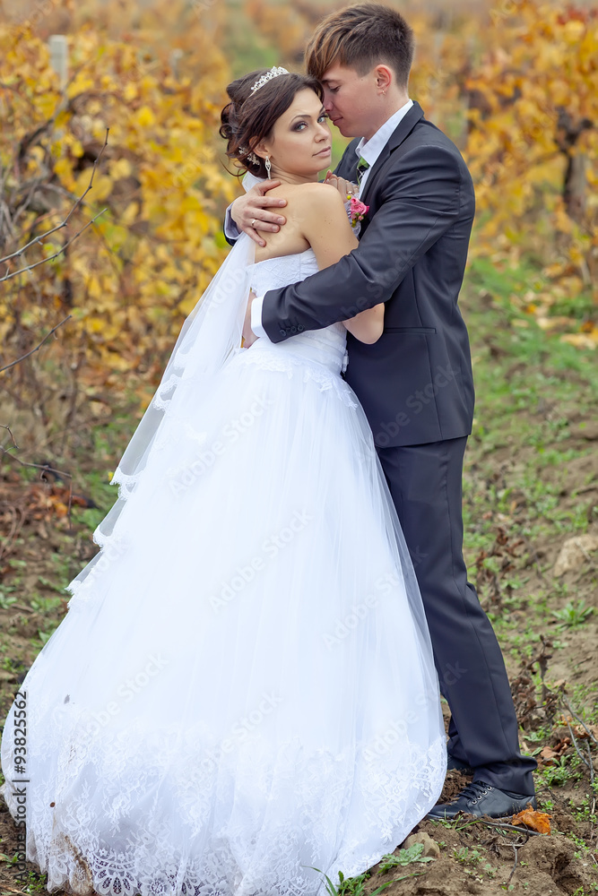 Happy new married are walking in autumn forest