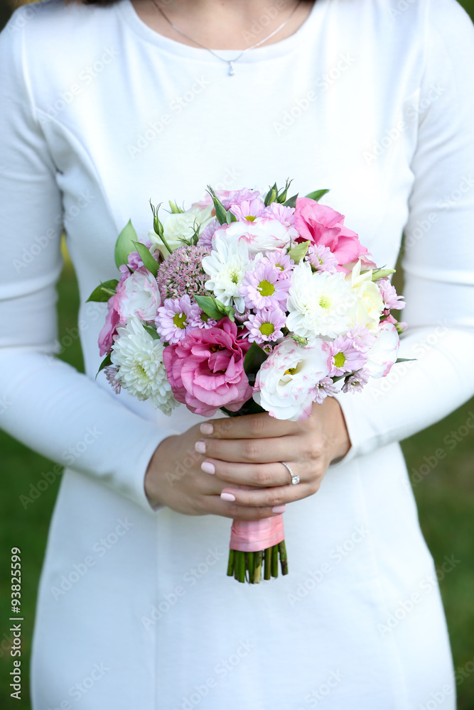 Beautiful wedding bouquet in hands of bride on nature background Beautiful wedding bouquet in hands of bride on nature background
