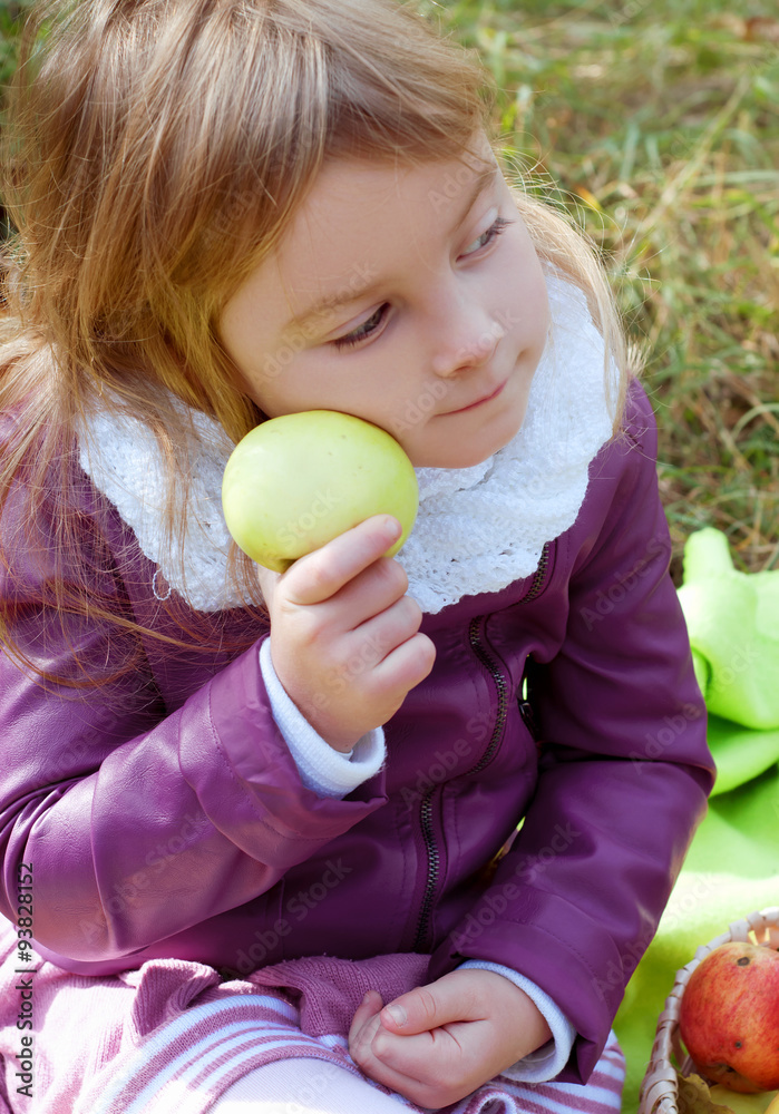 Cute little girl in autumn outfit in an apple orchard Cute little girl in autumn outfit in an apple orchard