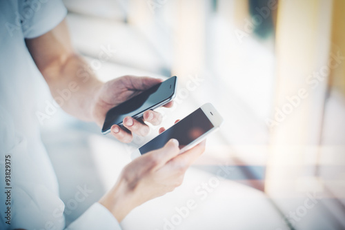 Man and young woman holding in hands their gadgets. They showing