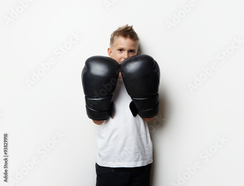 Cute little boy standing in boxing gloves and he ready to fight