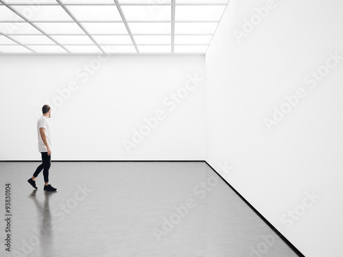 White interior with white canvas and young man. 