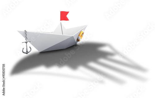 Paper boat origami with the shadow of a large ship - conceptual photo