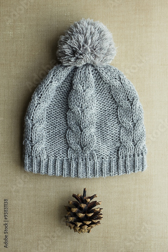 Knitted gray hat with pompom and pine cones