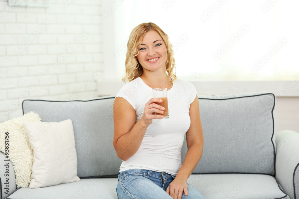Beautiful woman with glass of juice on home interior background Beautiful woman with glass of juice on home interior background